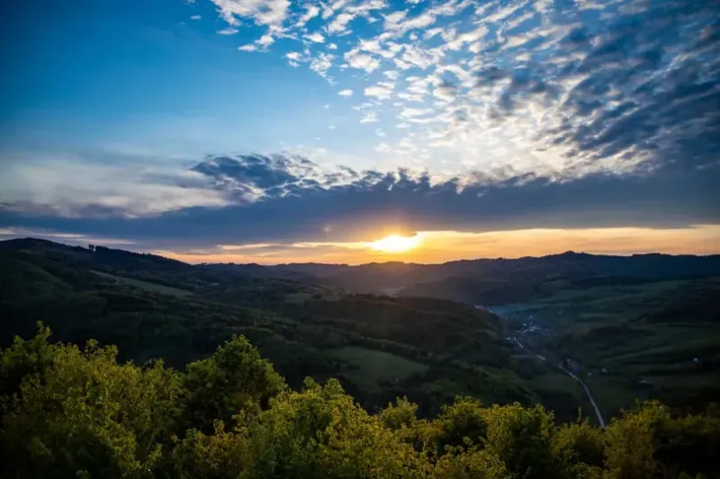 Sunset over agricultural and forest lands near Dohňany with dramatic clouds.