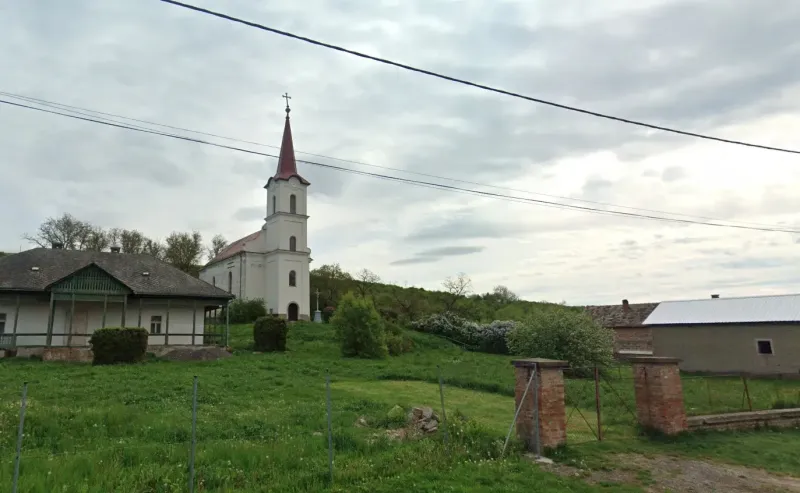 The church with a bell tower in Barca, surrounded by greenery and peculiar properties.