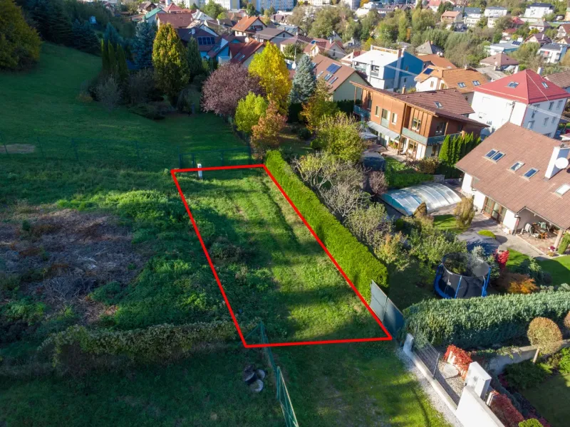 A plot in the Gardens of Banská Bystrica, surrounded by greenery and family houses.