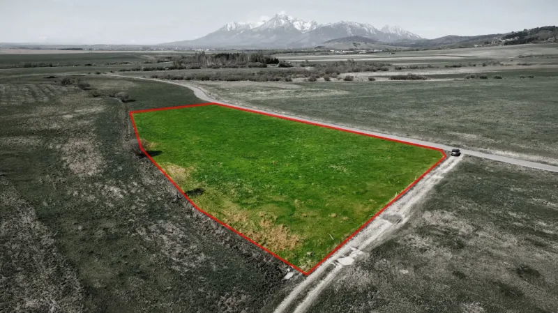Agricultural and forest land in Podhorany with a green plot and mountain panorama.