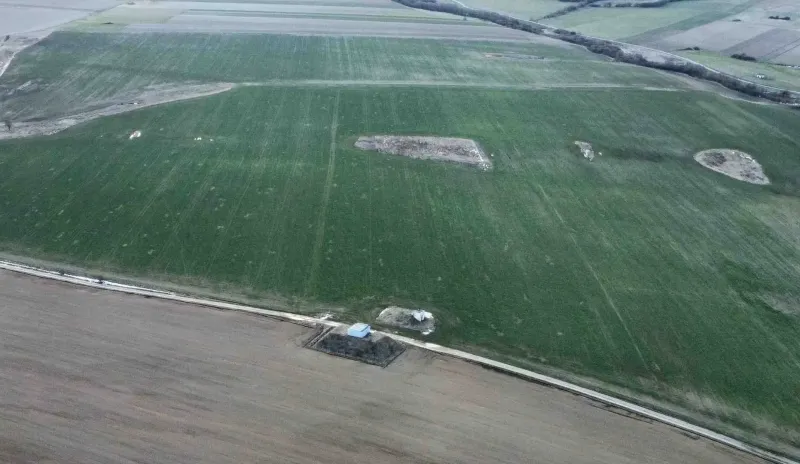 Aerial view of green agricultural and forest lands in Podhorany with scattered areas.