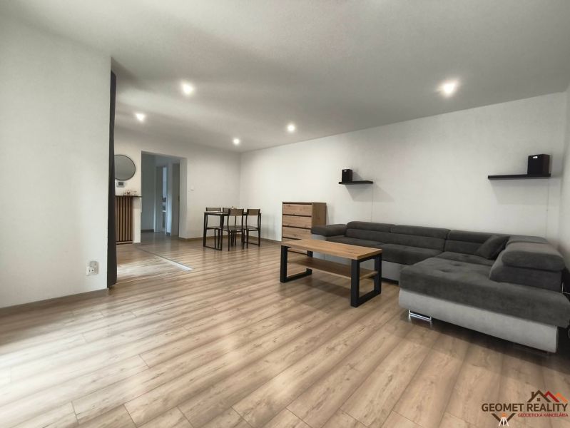 Living room in a family house with a wood-patterned floor and a comfortable sofa.