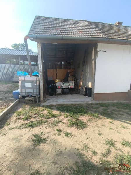 A family house in Dobroč on Dobroč Street, a shelter with tools and barrels for storage.