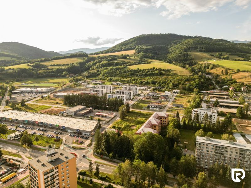 Aerial view of Plots - housing in the Barracks District, Brezno, with surrounding green hills.