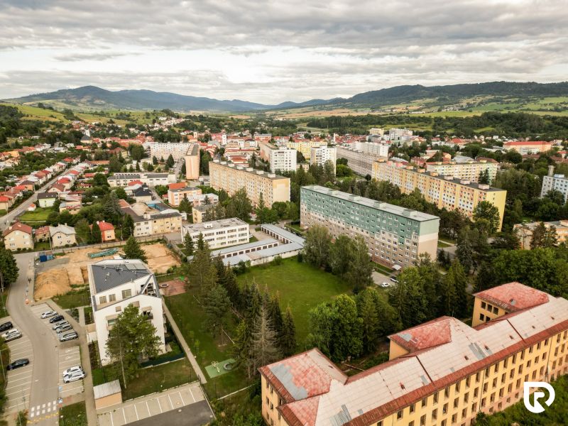 An aerial view of the Barracks Quarter in Brezno shows residential buildings and greenery.