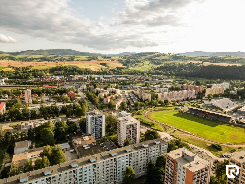 Aerial view of Plots - housing in the Barracks District in Brezno with a stadium and buildings.