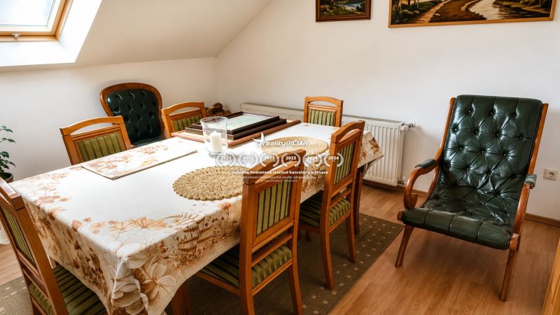 Dining room in a family house with wooden furniture and a wood-patterned floor.