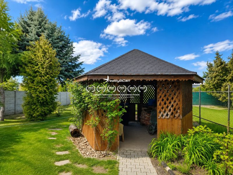 A garden with a gazebo at a family house on Hrnčiarska Street in Sereď, surrounded by greenery.