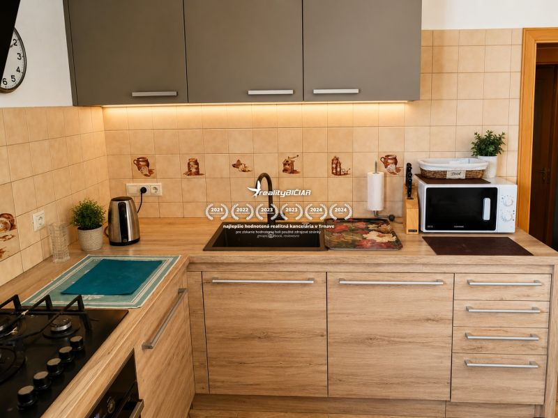 A kitchen with tiles and a wooden decor floor in a family house.