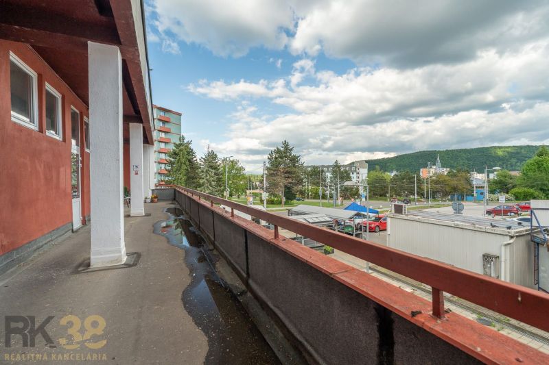A balcony of a building in Banská Bystrica with a view of the street and greenery.