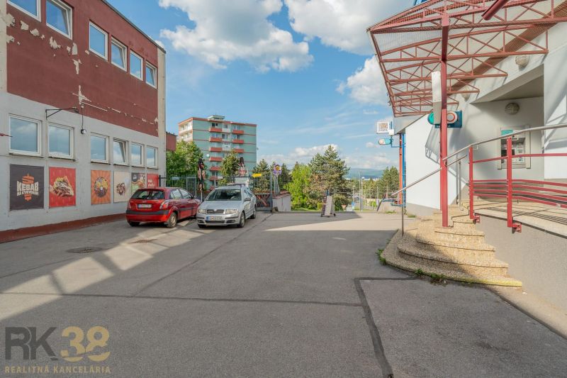 Parking lot in front of the building in Banská Bystrica with cars and outdoor staircases.