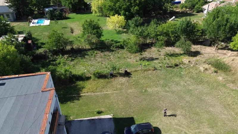 Aerial view of residential plots in Hronovce with greenery and parking.