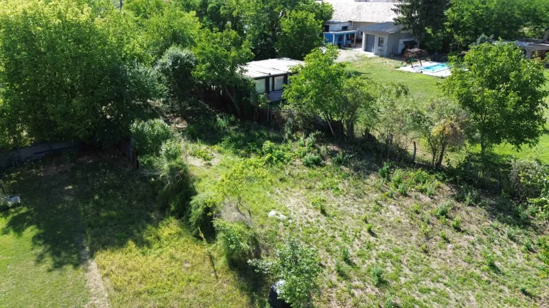 Greenery and land in Hronovce surrounded by trees, suitable for living.