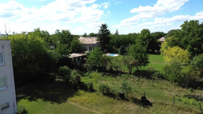 Greenery and houses in Hronovce, residential plots, with a visible swimming pool.