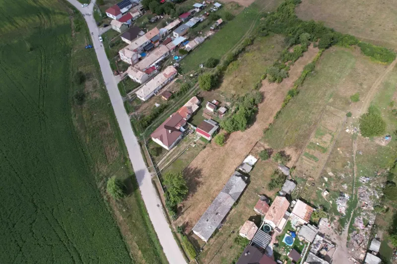 Aerial view of residential plots in Rakytník near the main road with adjacent buildings.