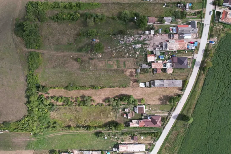 Aerial view of plots - housing in Rakytník, surrounded by greenery and buildings.