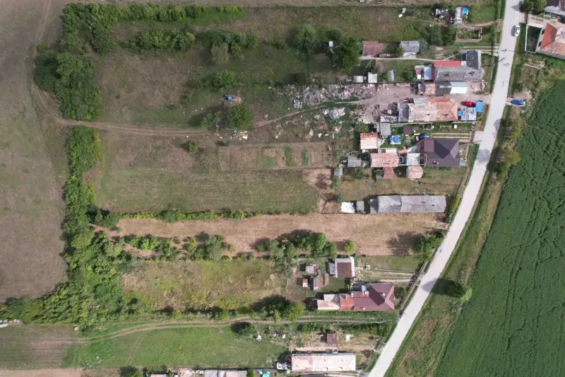 Aerial view of residential plots in Rakytník surrounded by greenery and buildings.