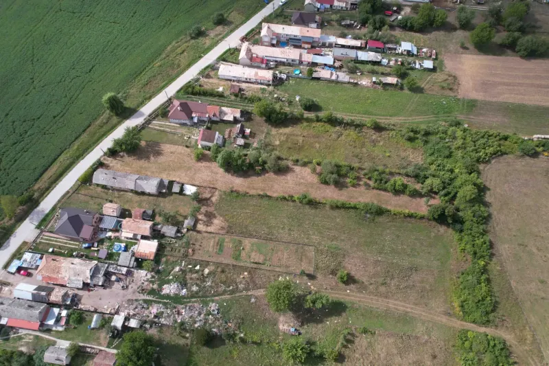 Aerial view of residential plots in the village of Rakytník, surrounded by greenery and houses.