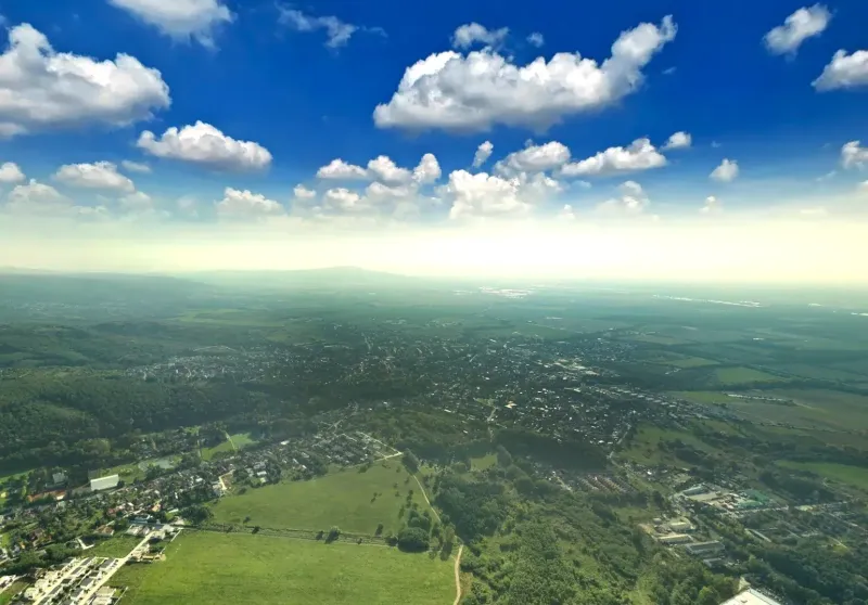Aerial view of agricultural and forest land in Stupava under a clear sky.