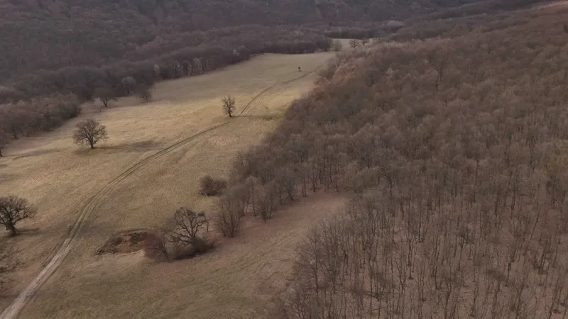 The landscape near Príbelce depicts agricultural and forest lands with scattered trees and dirt roads.