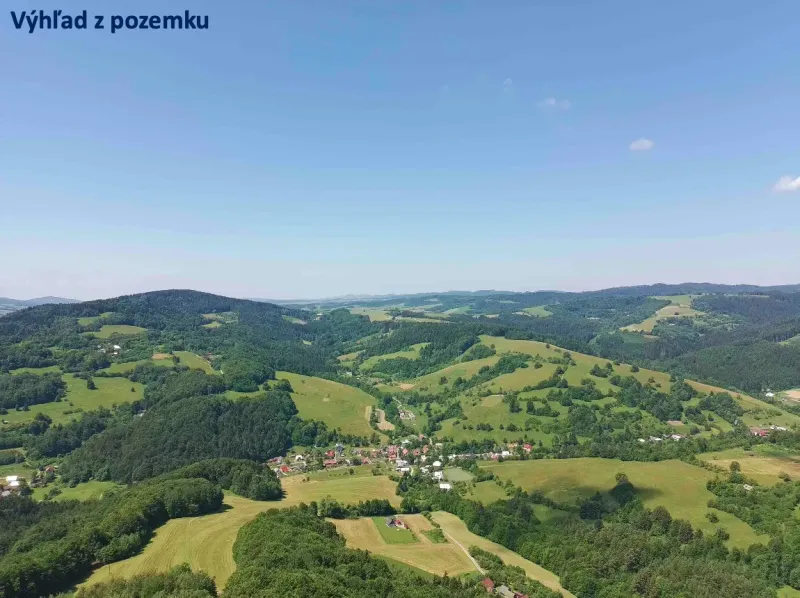 Rolling landscape of agricultural and forest lands near Lysá pod Makytou under a blue sky.