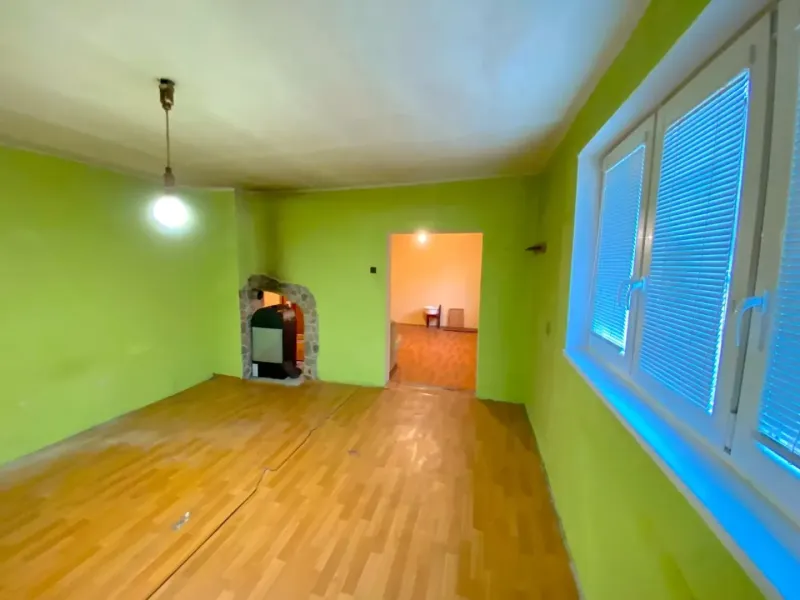 A room with a wooden floor decor and green walls in a family house.