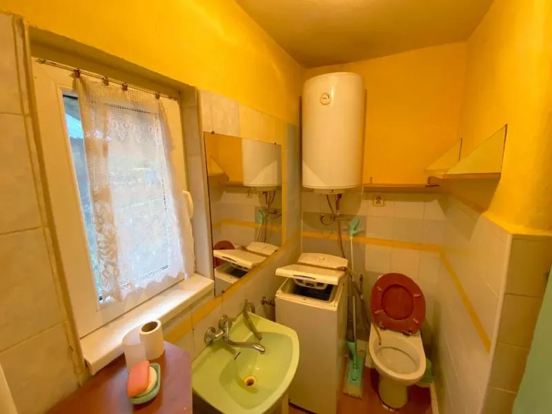 Bathroom in a family house with a sink, toilet, and heating boiler.