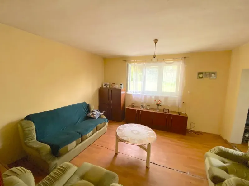 Living room in a family house with a sofa and wooden decor flooring.