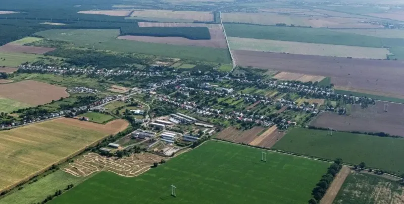 Aerial view of Trhovište with agricultural and forest lands surrounding the village.