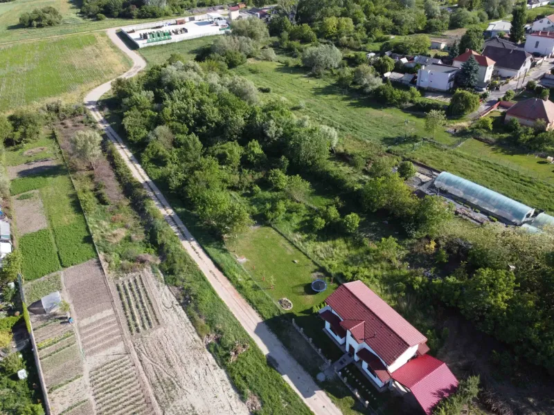 Aerial view of gardens in Branč with a house and a greenhouse.