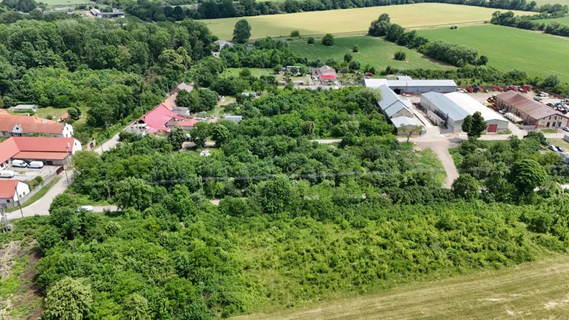 Aerial view of plots - housing in Parchovany, surrounded by greenery and buildings.