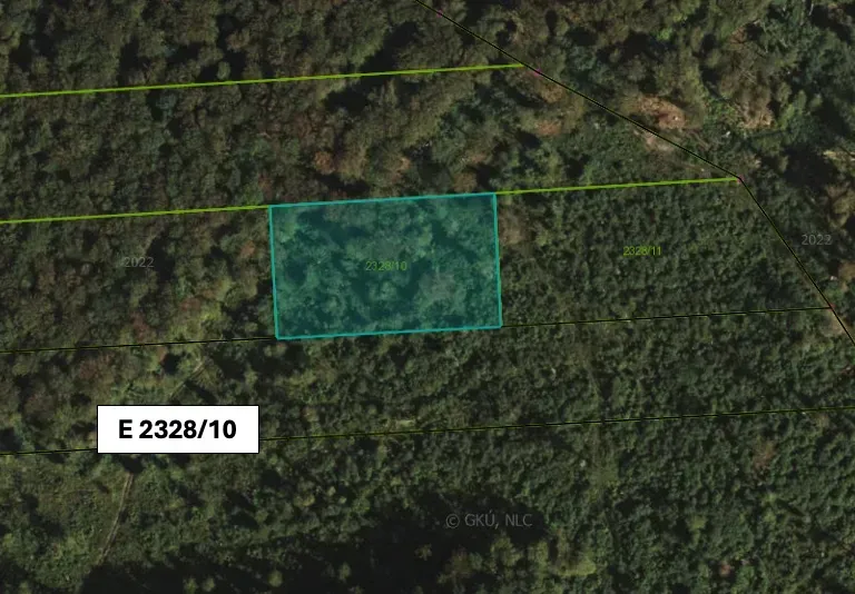 Aerial view of agricultural and forest land in Koňuš surrounded by dense forest.