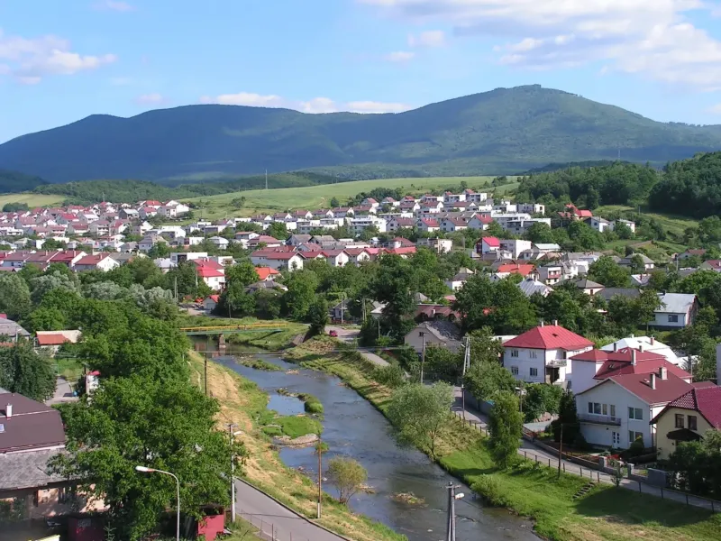 Panorama of Snina with a river, houses, and hills in the area of Special Properties.