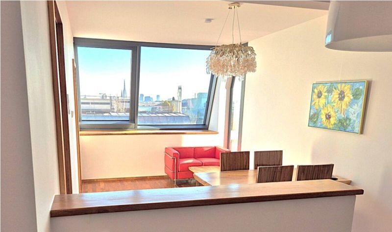 Dining area in a 2-room apartment with a view and wooden decor flooring.
