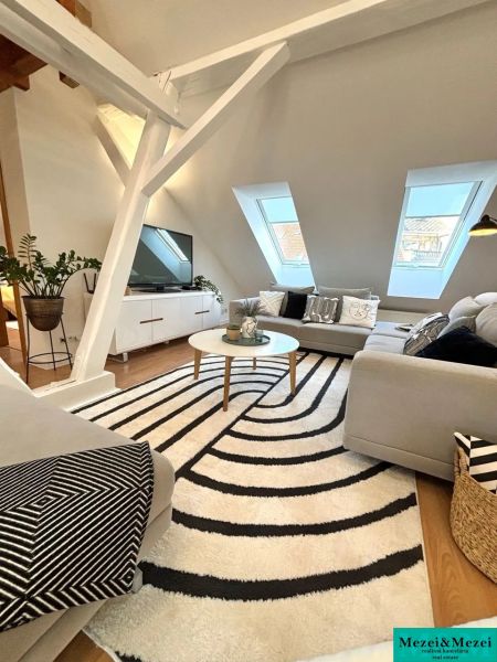A bright living room with a sofa and a patterned carpet in a 4-room apartment.