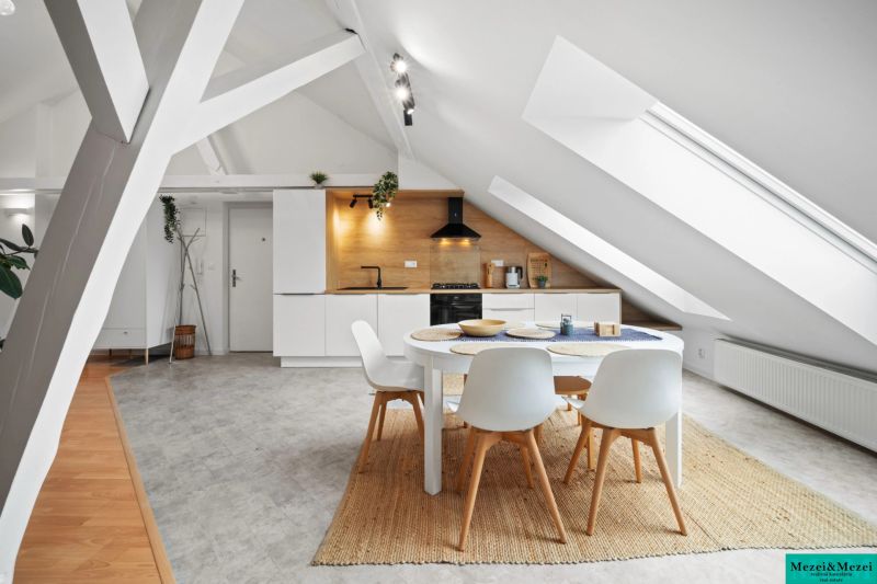 An attic kitchen in a 4-room apartment with modern appliances and a round table.