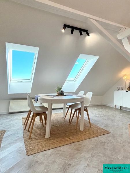 Dining nook with skylights and a round table in a 4-room apartment.