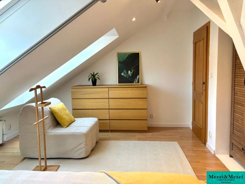 Attic room in a 4-room apartment with wooden decor and light furniture.