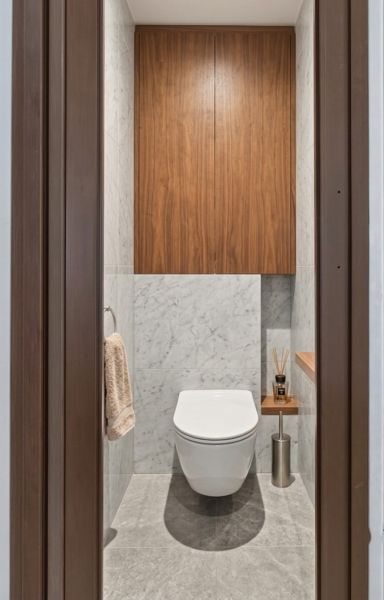 A bathroom in a one-room apartment with wooden paneling and marble tiles.