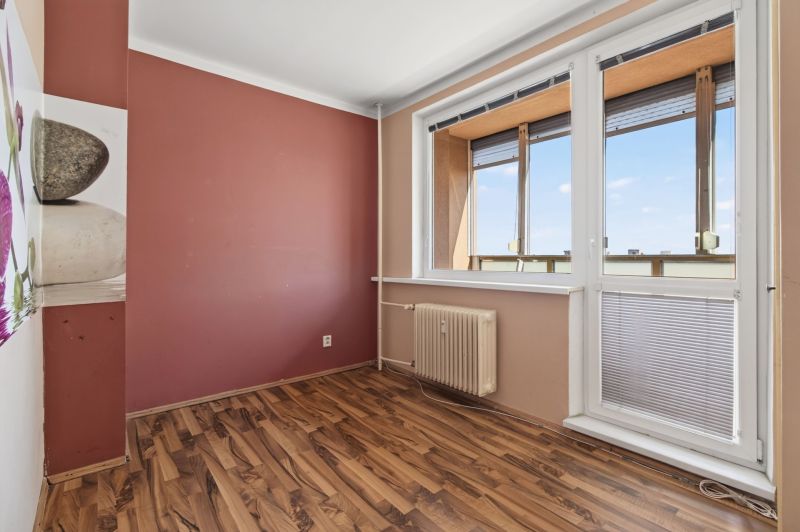 A room in a one-room apartment with a window and a floor with a wooden decor.