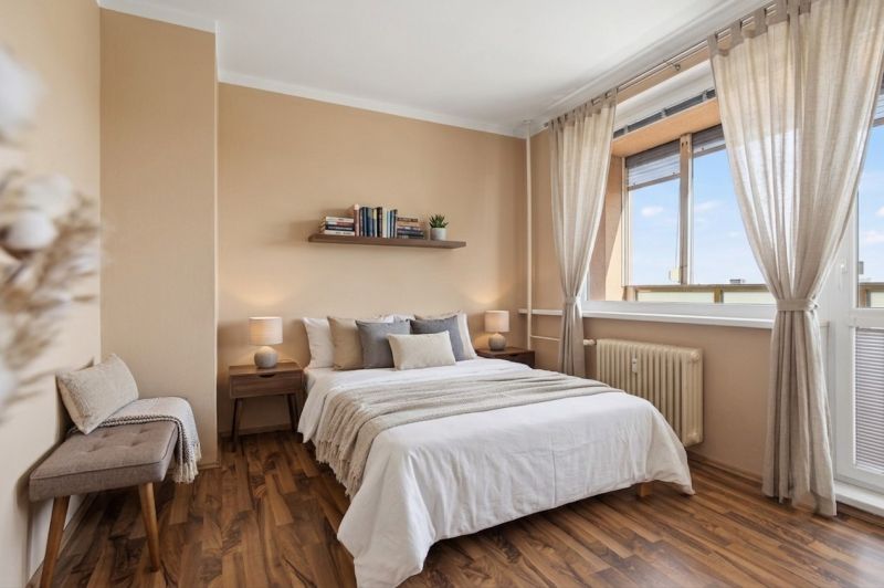 Bedroom with wood-decor flooring in a studio apartment, cozy interior with decorations.