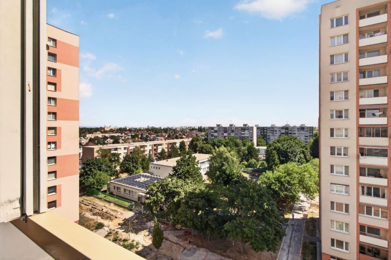 The view from the balcony of a one-room apartment on Jiráskova Street in Trnava, with blocks and greenery.
