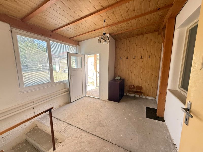 Interior of a family house with wooden paneling and entrance door.