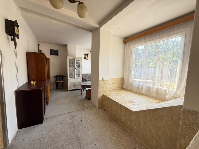 Living room in a family house with a large window and furniture.