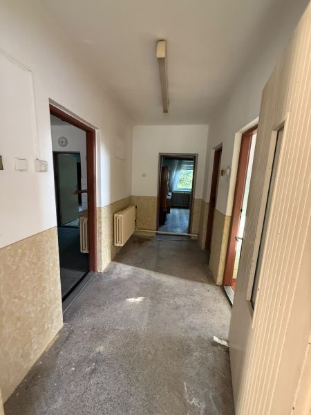 A hallway in a family house with a view into the rooms and radiators on the walls.