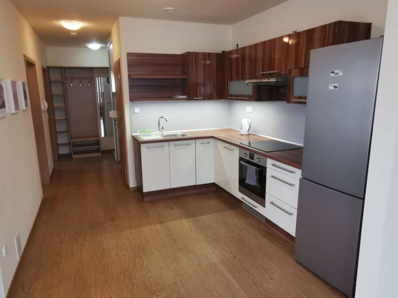 A kitchen in a family house with a wooden decor floor and built-in cabinets.