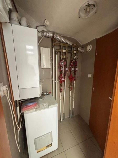 Boiler room with piping and boiler in commercial premises.
