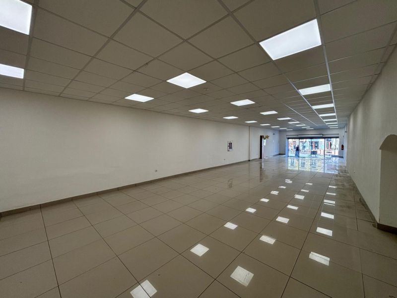 Commercial spaces with large windows and tiled floors.