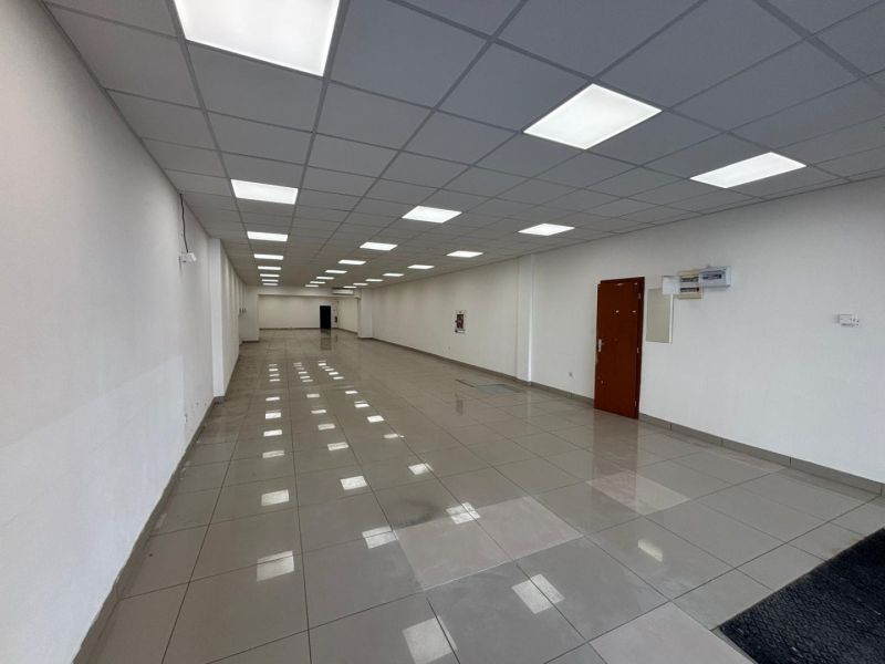 Spacious commercial spaces with white walls and shiny floors.