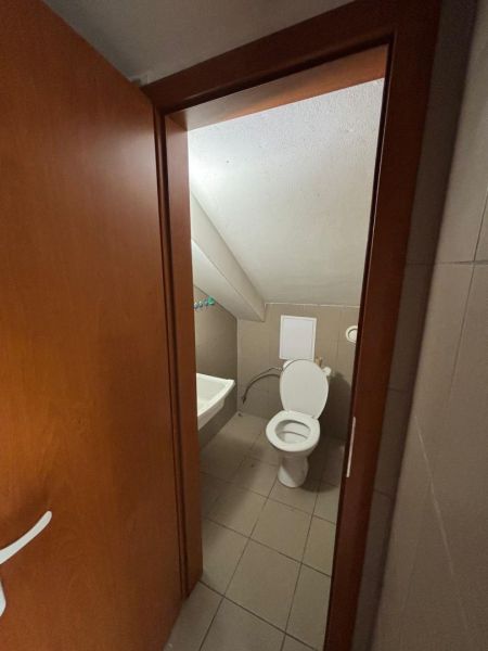Restroom with a toilet and a sink in commercial premises.